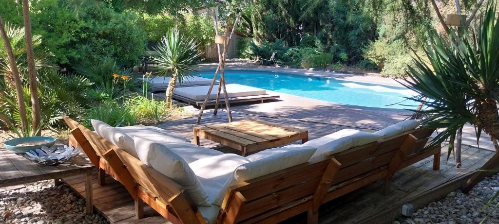 ドラギニャンにあるle jardinのベンチとテーブル付きのスイミングプールを併設しています。