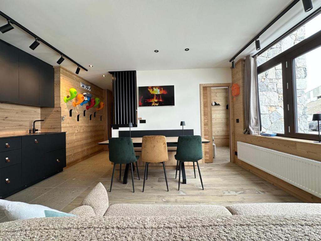 une cuisine et une salle à manger avec une table et des chaises dans l'établissement Appartement T3 - Emplacement exceptionnel - entrée indépendante - entièrement rénové, à Tignes