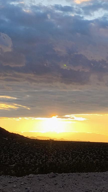 a sunset in the desert with the sun setting at Simply Camping in Hidden River