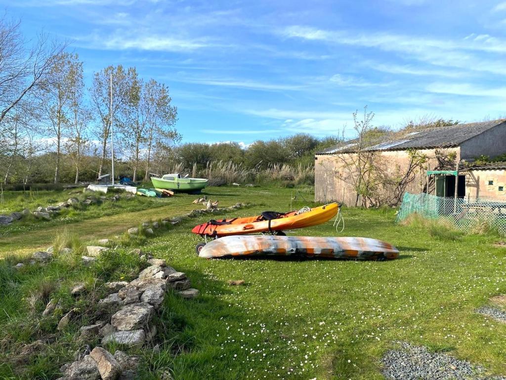 Trois kayaks assis sur l'herbe dans un champ dans l'établissement gite du mouton pêcheur, à Penmarcʼh