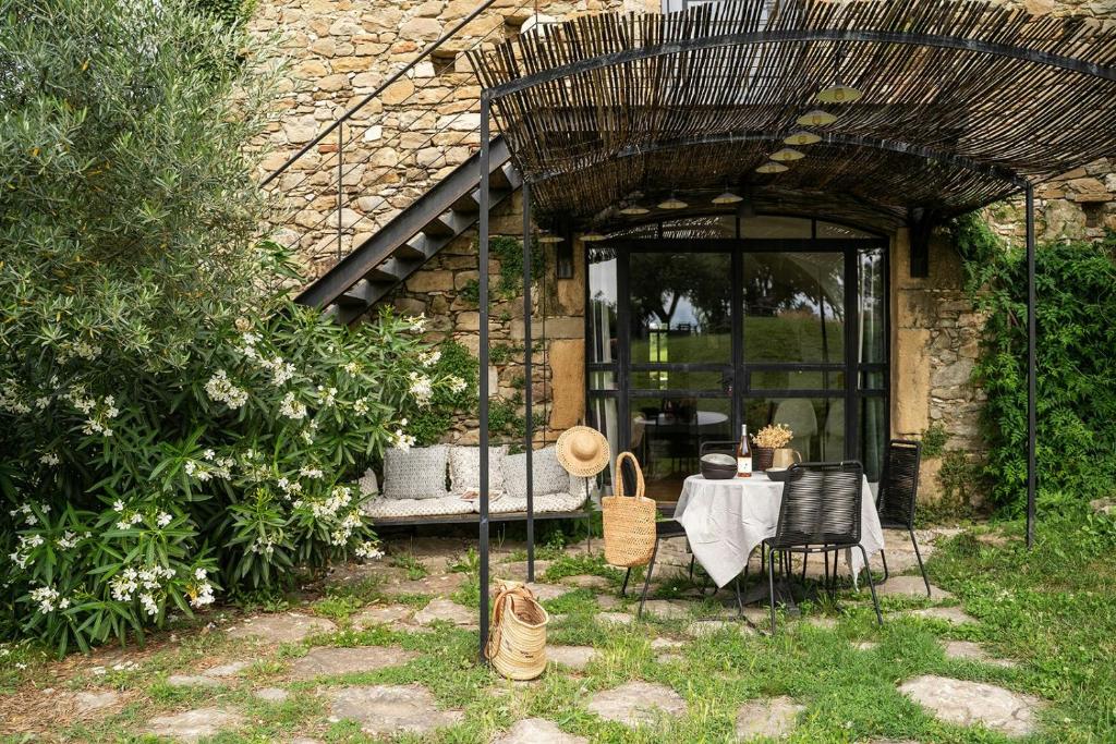 d'une terrasse avec une table et des chaises dans le jardin. dans l'établissement Former Sheepfold With Natural Shared Pool In Drôme, à Puy-Saint-Martin
