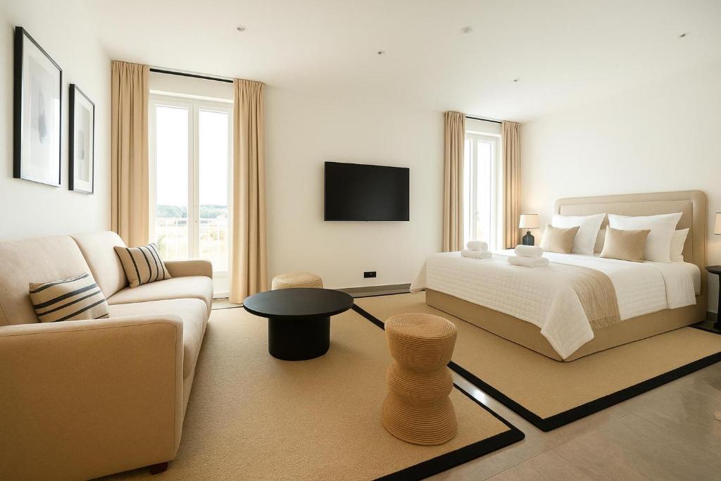 - une chambre blanche avec un lit et un canapé dans l'établissement Seaview Studio, Palais des Festivals, à Cannes