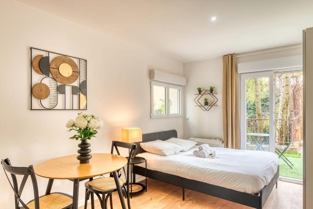 une chambre avec un lit, une table et des chaises dans l'établissement Le Petit Atelier - Climatisé extérieur - Jean Macé, à Lyon