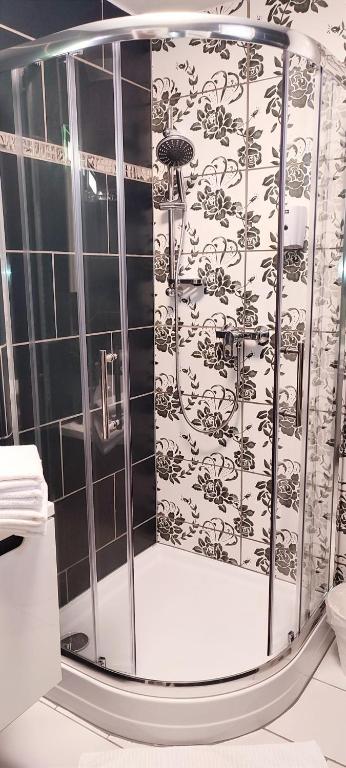 un bagno con doccia e piastrelle bianche e nere di Tinyhouses am Neusiedlersee a Fertőrákos