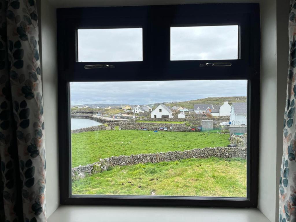 a window with a view of a green field at Tigh Fitz Apartments - Inis Mór, Aran Island in Inis Mor