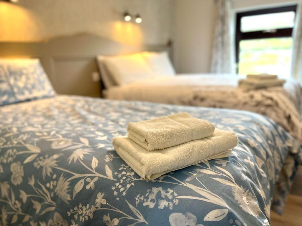 a bed with two towels sitting on top of it at Tigh Fitz Apartments - Inis Mór, Aran Island in Inis Mor