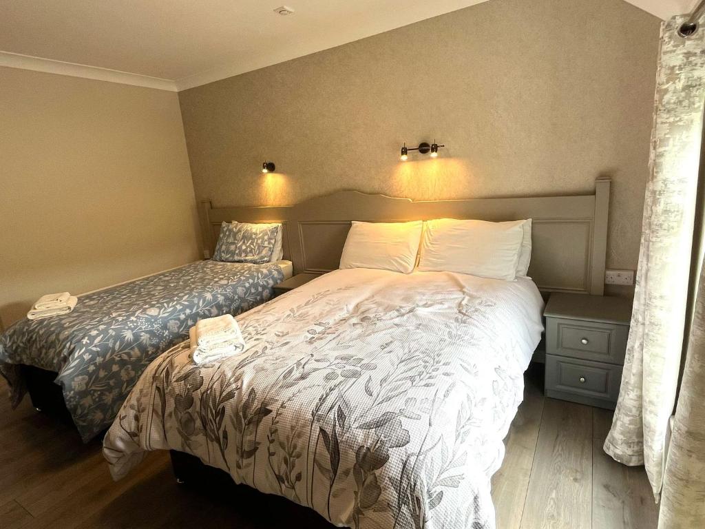 a bedroom with a bed and a nightstand and a bed sidx sidx sidx sidx at Tigh Fitz Apartments - Inis Mór, Aran Island in Inis Mor