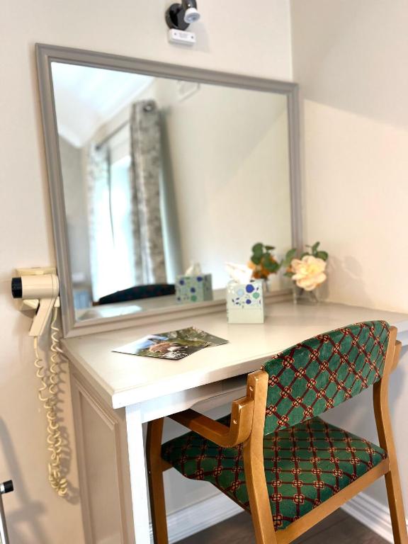 a dressing table with a chair and a mirror at Tigh Fitz Apartments - Inis Mór, Aran Island in Inis Mor