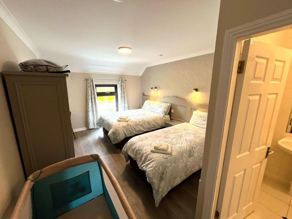 a small bedroom with two beds and a window at Tigh Fitz Apartments - Inis Mór, Aran Island in Inis Mor