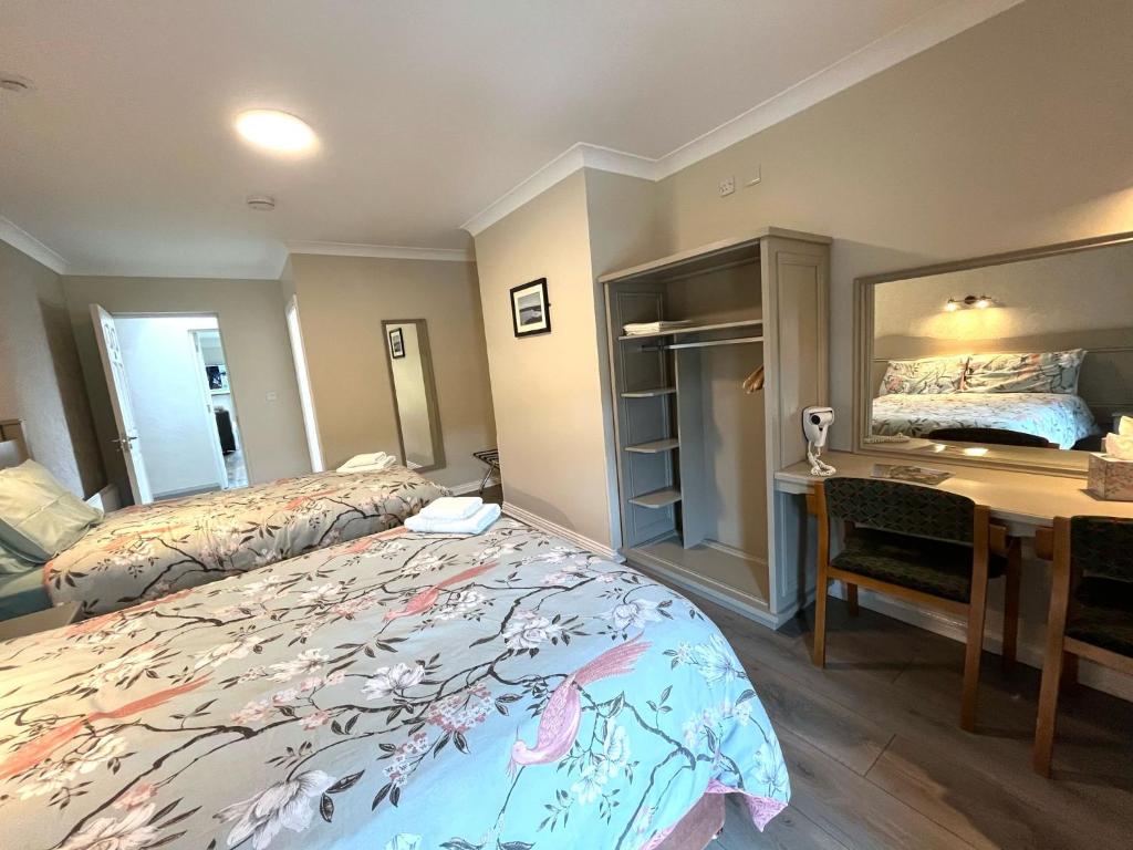 a hotel room with two beds and a desk and a desk at Tigh Fitz Apartments - Inis Mór, Aran Island in Inis Mor