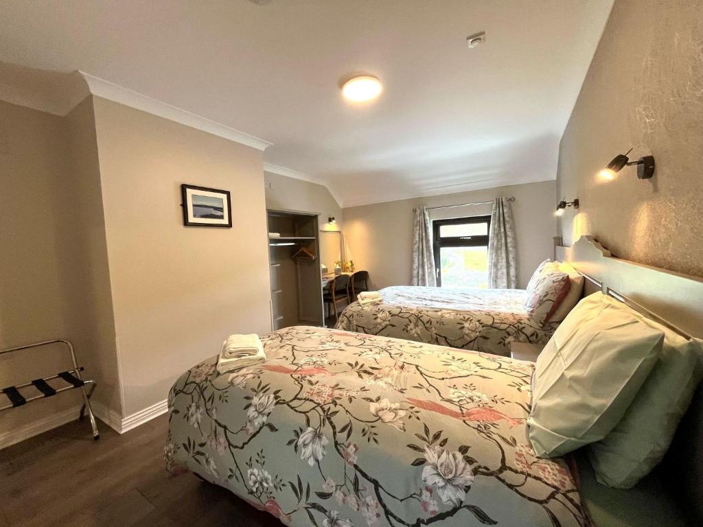 a bedroom with two beds and a window at Tigh Fitz Apartments - Inis Mór, Aran Island in Inis Mor