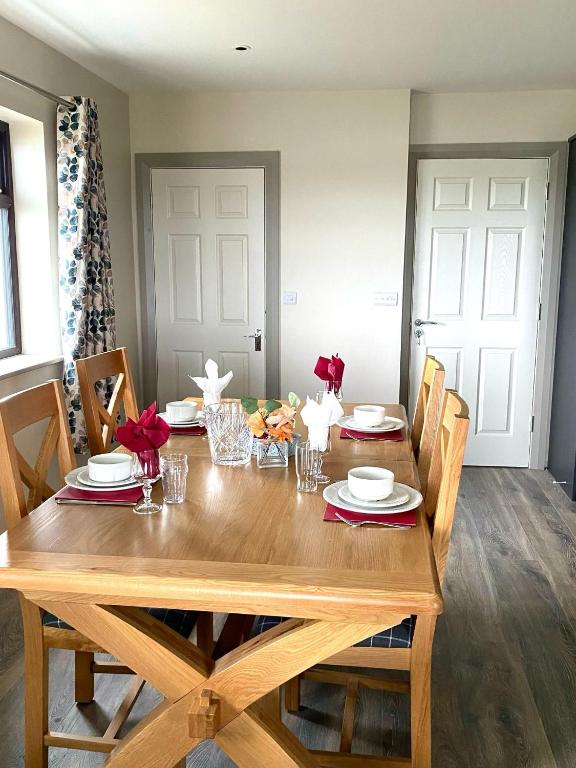 a wooden table with chairs and a dining room at Tigh Fitz Apartments - Inis Mór, Aran Island in Inis Mor