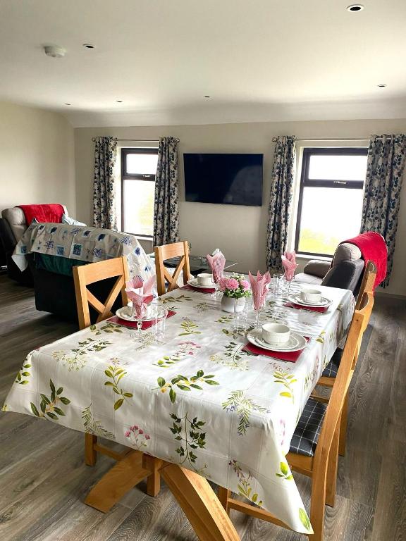 a dining room table with a white table cloth on it at Tigh Fitz Apartments - Inis Mór, Aran Island in Inis Mor