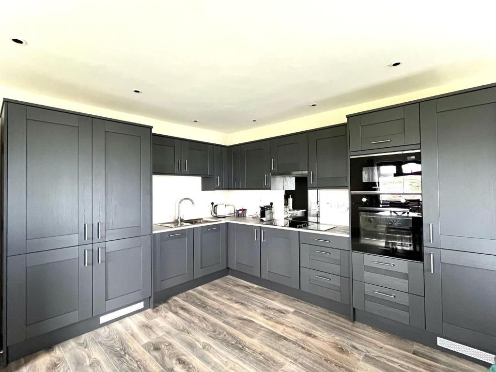 a large kitchen with gray cabinets and appliances at Tigh Fitz Apartments - Inis Mór, Aran Island in Inis Mor