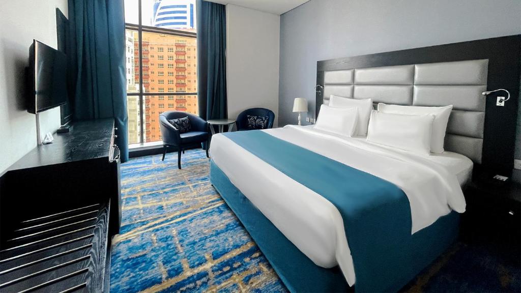 a hotel room with a large bed and a large window at Signature 1 Hotel Tecom in Dubai