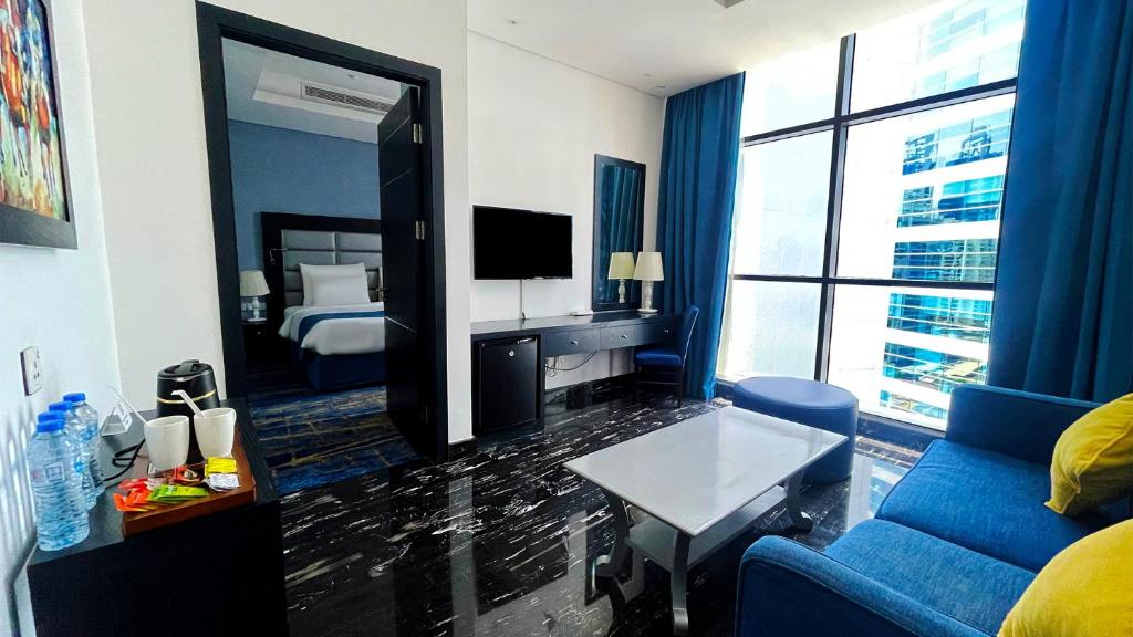 a living room with a blue couch and a large mirror at Signature 1 Hotel Tecom in Dubai