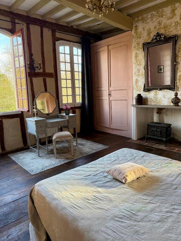 une chambre avec un grand lit et une table dans l'établissement Domaine de la Hargue, à Manciet