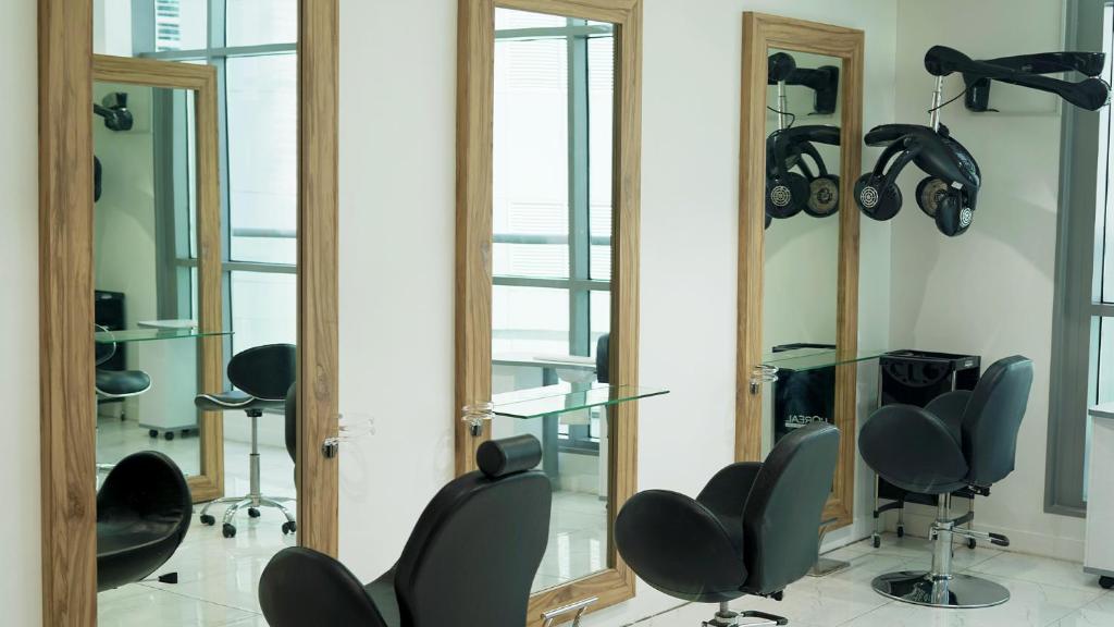 a salon with mirrors and chairs in a room at Signature 1 Hotel Tecom in Dubai