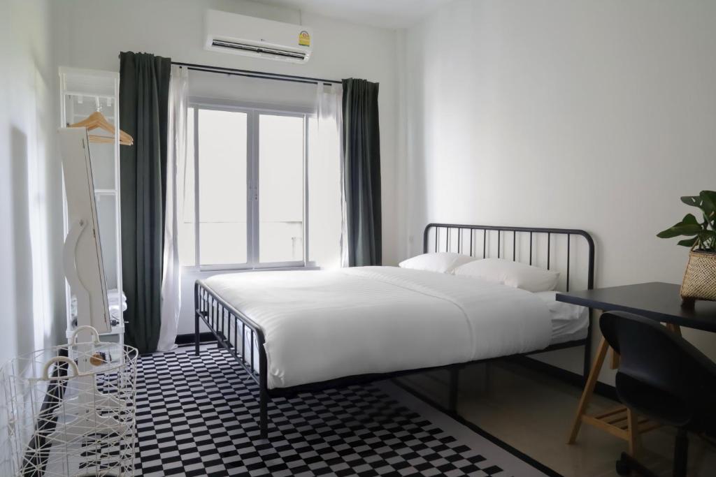 a bedroom with a white bed and a window at Ralf House in Hua Hin