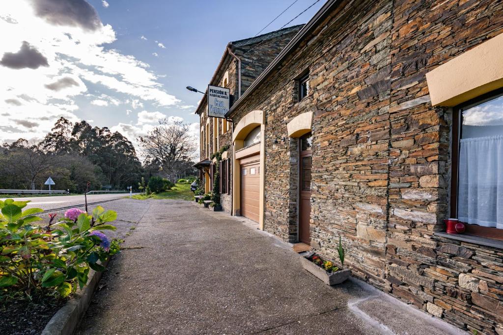 un bâtiment en briques avec une porte donnant sur une rue dans l'établissement Ático Casa Venancio, à Trabada