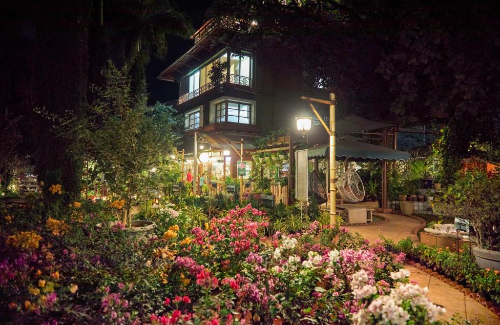a flower garden in front of a building at night at Nestay in Karnāla