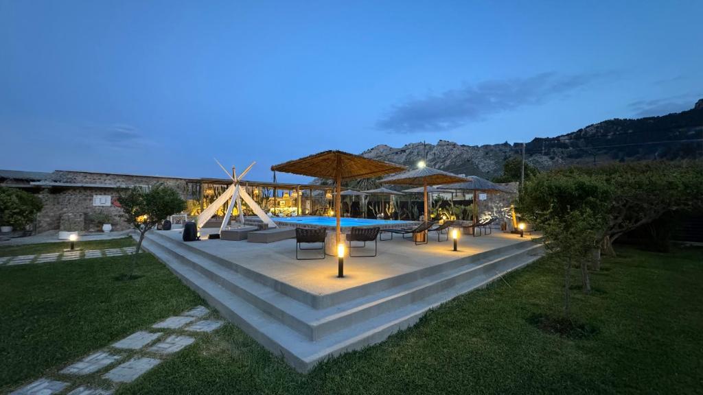 patio ze stołem i krzesłami oraz basenem w obiekcie LA Casa Di Lusso N7 -Adults Only w Kolymbii
