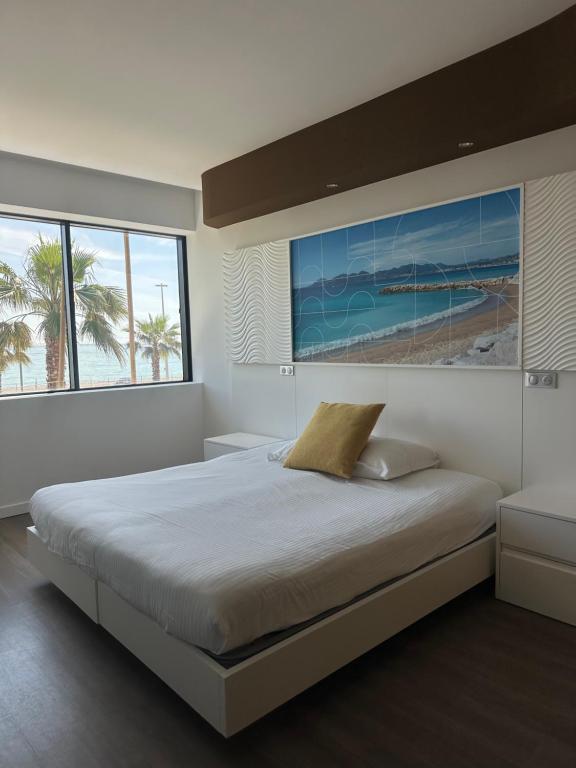 a bedroom with a large bed with a view of the beach at SoBlue Hôtel in Antibes