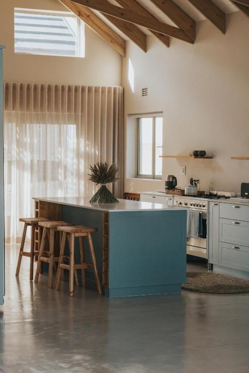 a kitchen with a blue island in a room at Sandown Synergy Lagoon House in Hermanus