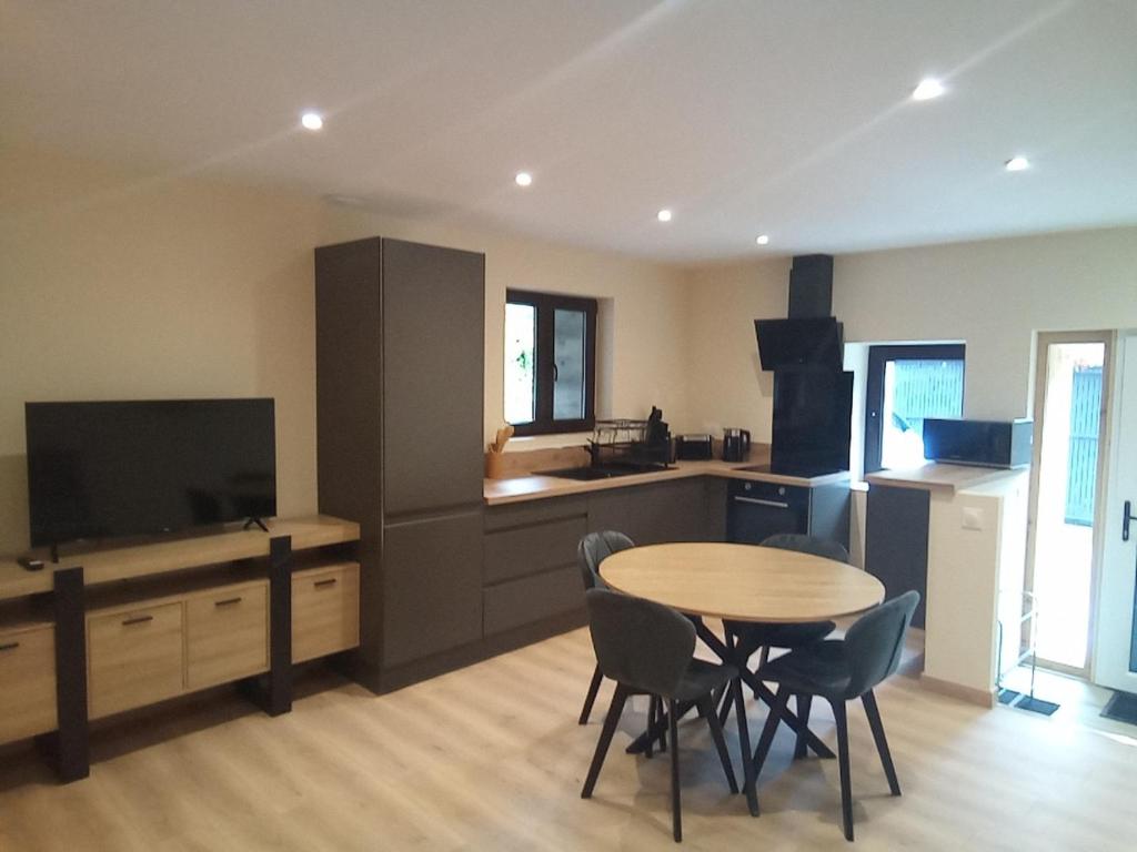 a kitchen with a table and chairs in a room at Gîte de la marmotte in Chevaline