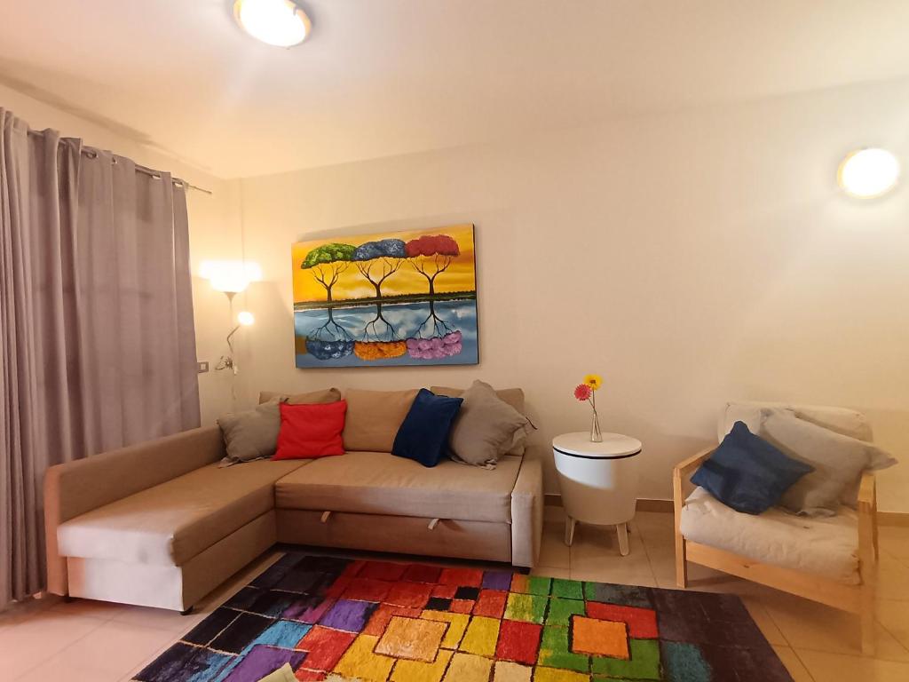 ein Wohnzimmer mit einer Couch und einem Gemälde an der Wand in der Unterkunft Atlantico breeze in Costa Del Silencio