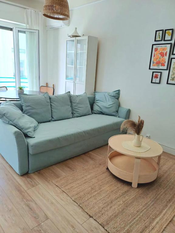 un salon avec un canapé bleu et une table dans l'établissement Charmant T2 proche tramway et plages, à Nice