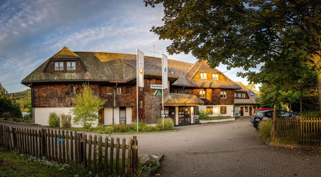 een groot bakstenen gebouw met een hek ervoor bij Jugendherberge Schluchsee-Wolfsgrund in Schluchsee