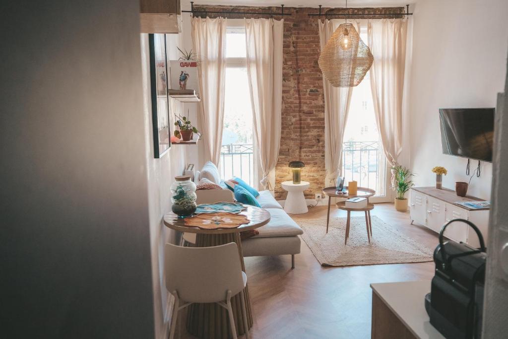 un salon avec un canapé et une table dans l'établissement Le nid enchanté, à Perpignan