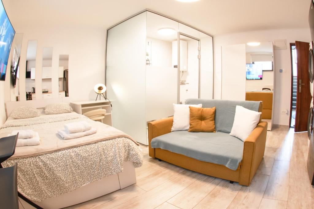 a bedroom with a bed and a chair and a mirror at Cozy Condo in Tresnjevka in Zagreb