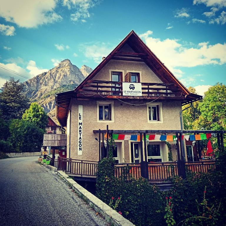 un bâtiment situé sur le côté d'une route dans l'établissement Hôtel Le Martagon, à Villars-Colmars