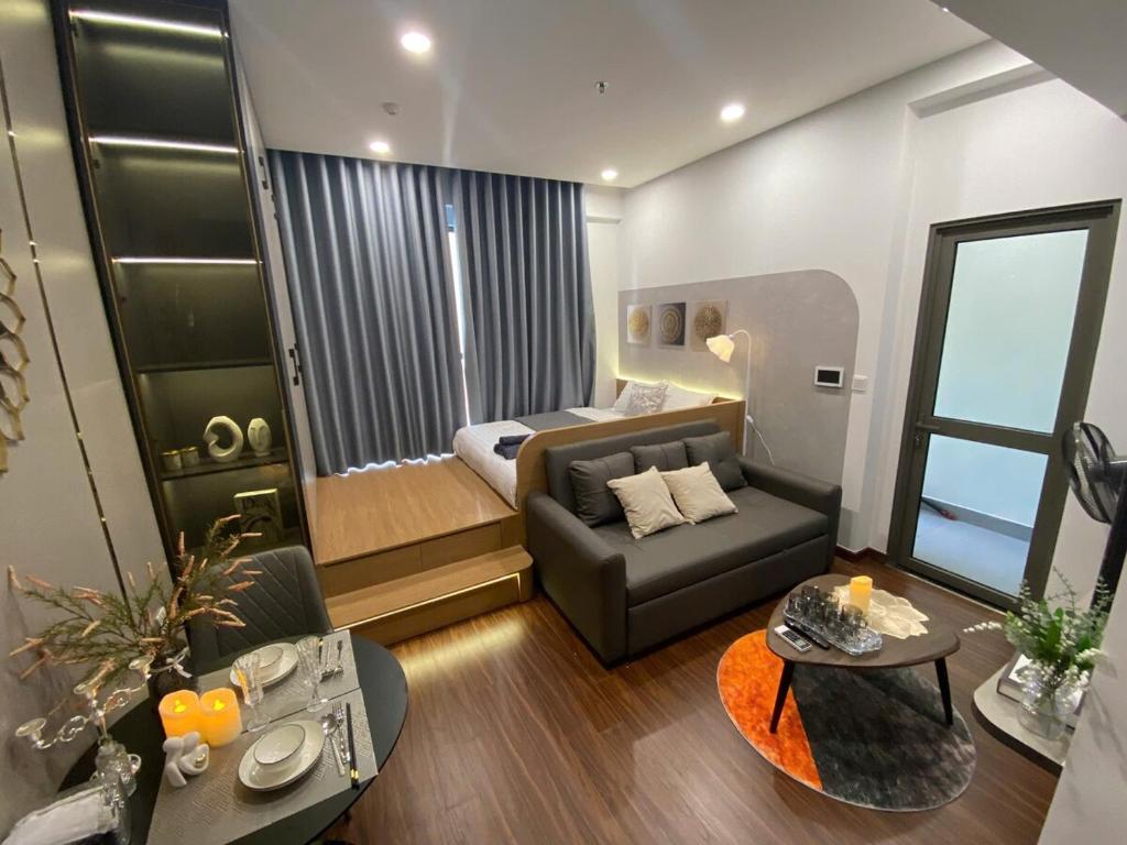 a living room with a couch and a bed at Lustay StudioH3 Hawaii Masteri- Luxury Furnished in Gia Lâm Pho