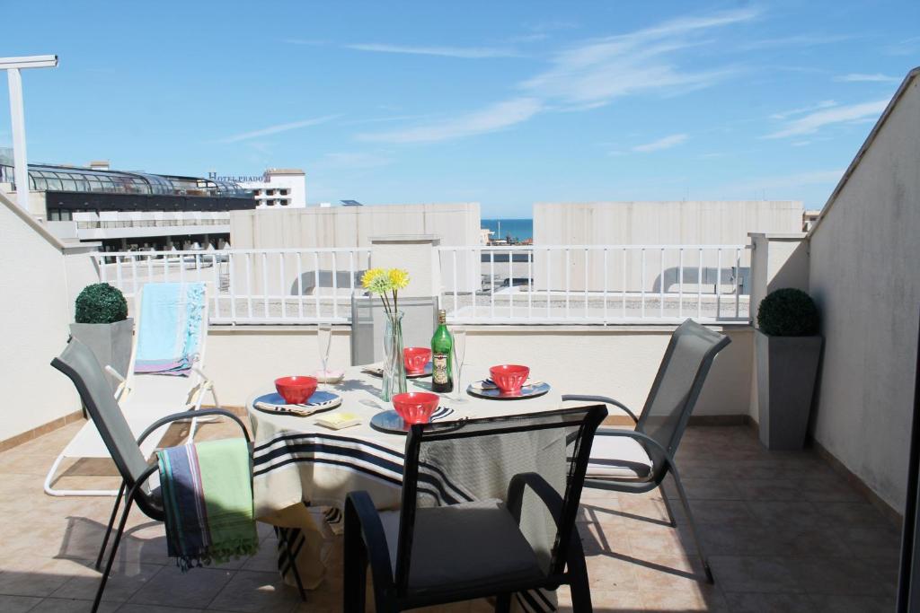 a balcony with a table and chairs on a roof at Atico Palacio de congresos in Peniscola