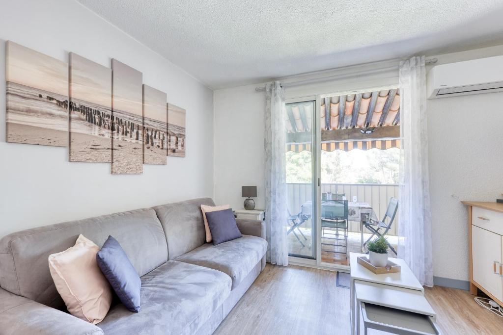 un salon avec un canapé et une fenêtre dans l'établissement Les Cigales de la Mer - 7min à pied du Port, à Saint-Cyr-sur-Mer