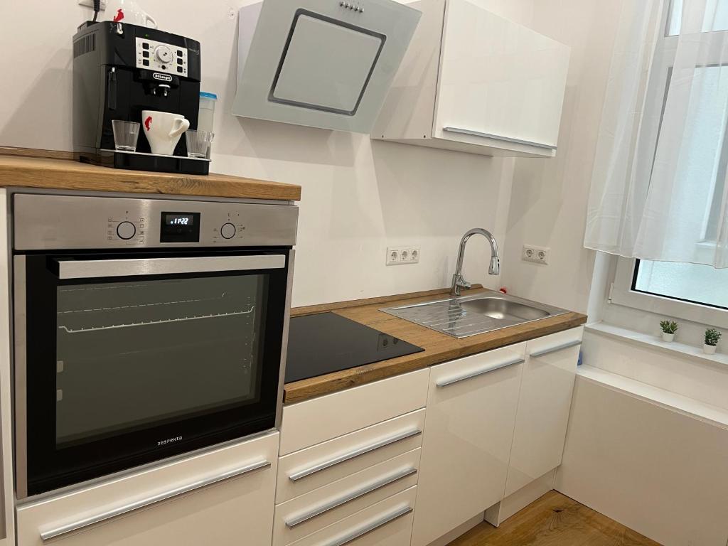 a small kitchen with a sink and a microwave at Nook - Zentrale Lage - an der ListerMeile in Hannover