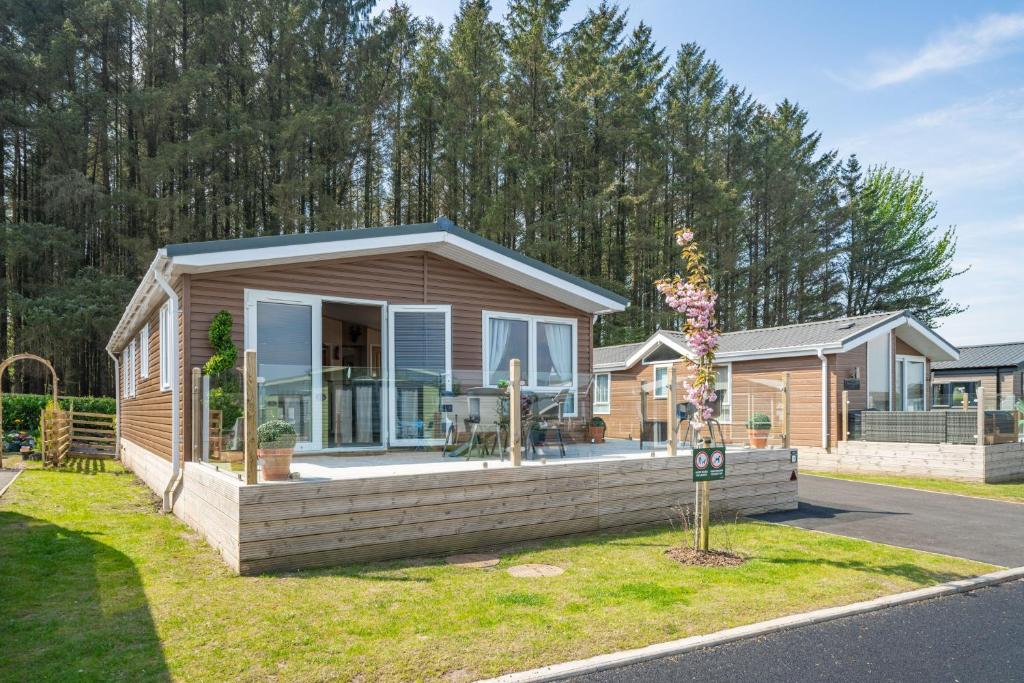 a home with a porch and a house at Antler Lodge - Meadows Retreat Lodge Park in Plumbland