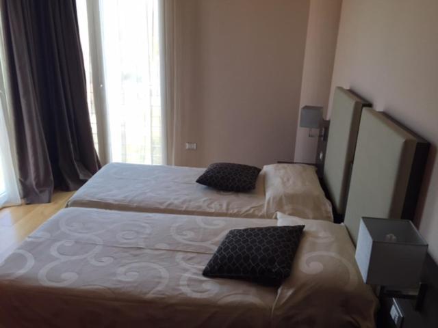 a hotel room with two beds and a window at Zen Hotel Versilia in Marina di Pietrasanta