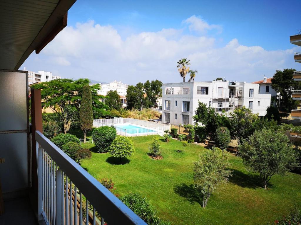 - un balcon avec vue sur la cour et la piscine dans l'établissement Pont du Lys - proche plages - piscine, à Juan-les-Pins
