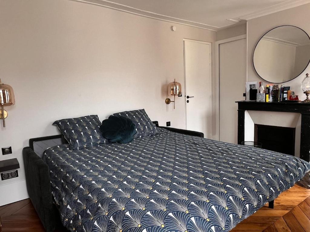 a bedroom with a bed and a mirror at Studio indépendant 27 m2 Jardin du Luxembourg in Paris