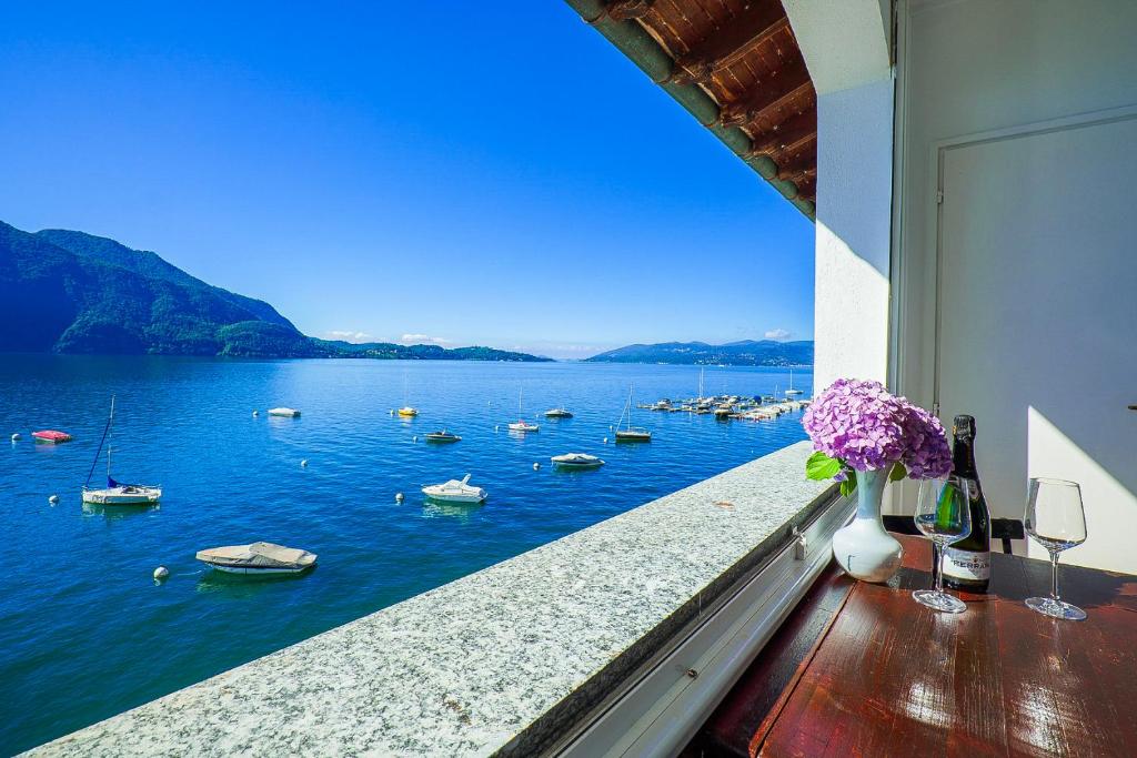 a balcony with a view of a body of water with boats at La Fabbrichetta Leonardolake in Ghiffa