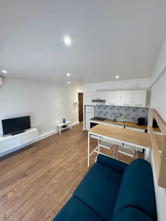 un salon avec un canapé bleu et une table dans l'établissement Joli Appartement 2 pieces Cannes, à Cannes