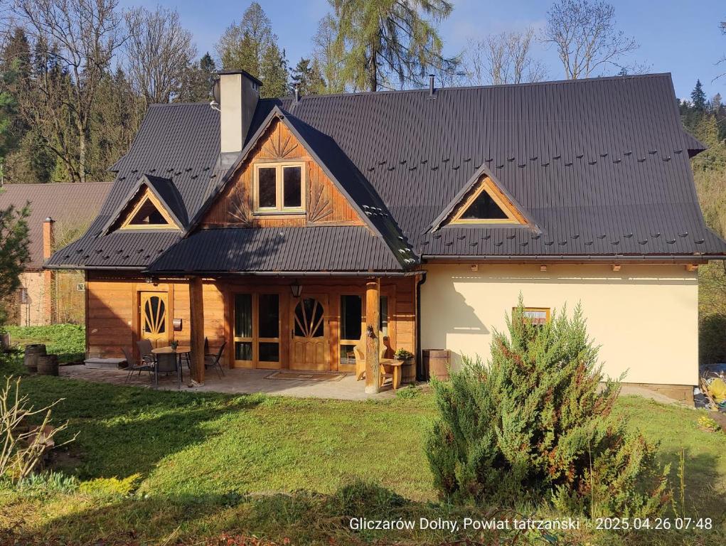 a large house with a black roof at GLICZAROWA OSADA, Chata 18 osób, Domek 8 osób NA WYŁĄCZNOŚĆ, 8 sypialni z łazienkami, spokój, przyroda, wyjątkowe miejsce in Gliczarów