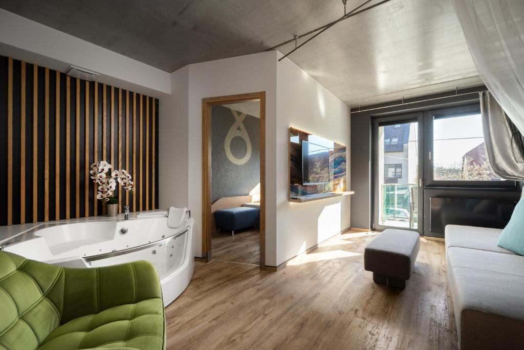 Un baño grande con bañera y un dormitorio. en Onyx Luxury, en Sárvár