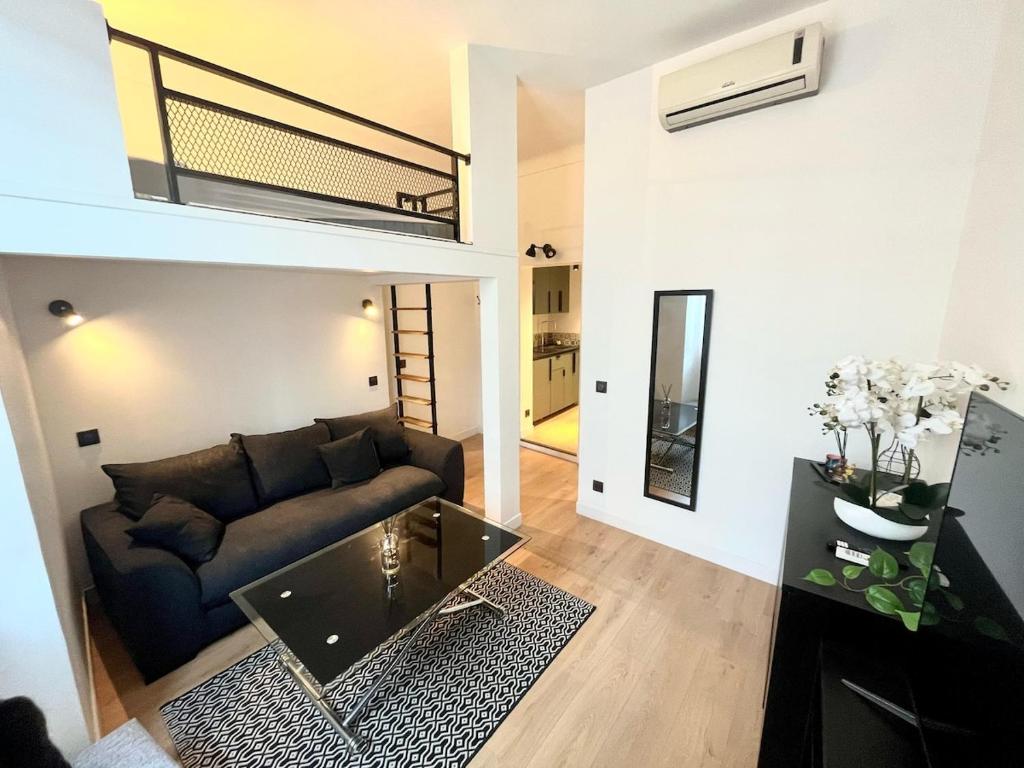 un salon avec un canapé et une mezzanine dans l'établissement Studio Neuf Clim 4p - Cannes, à Cannes