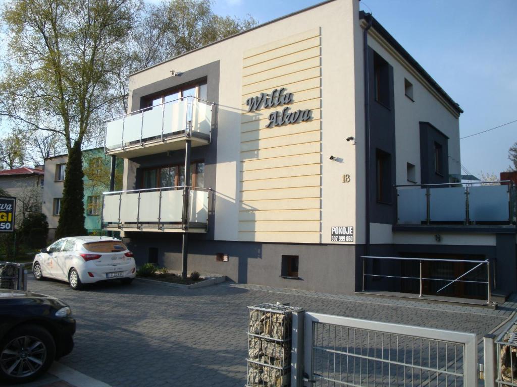 un edificio con un coche aparcado en un aparcamiento en Willa Alwa, en Iława