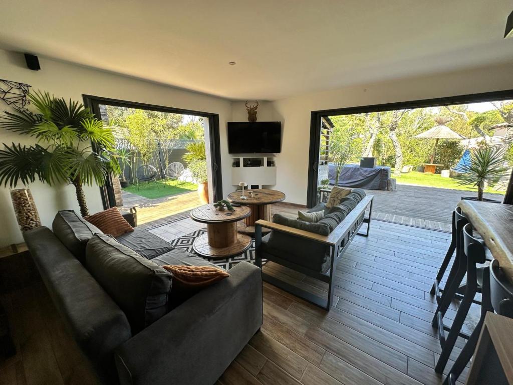 a living room with couches and a large sliding glass door at VILLA FENG SHUI déco bali St Aygulf 3 chambres in Saint-Aygulf